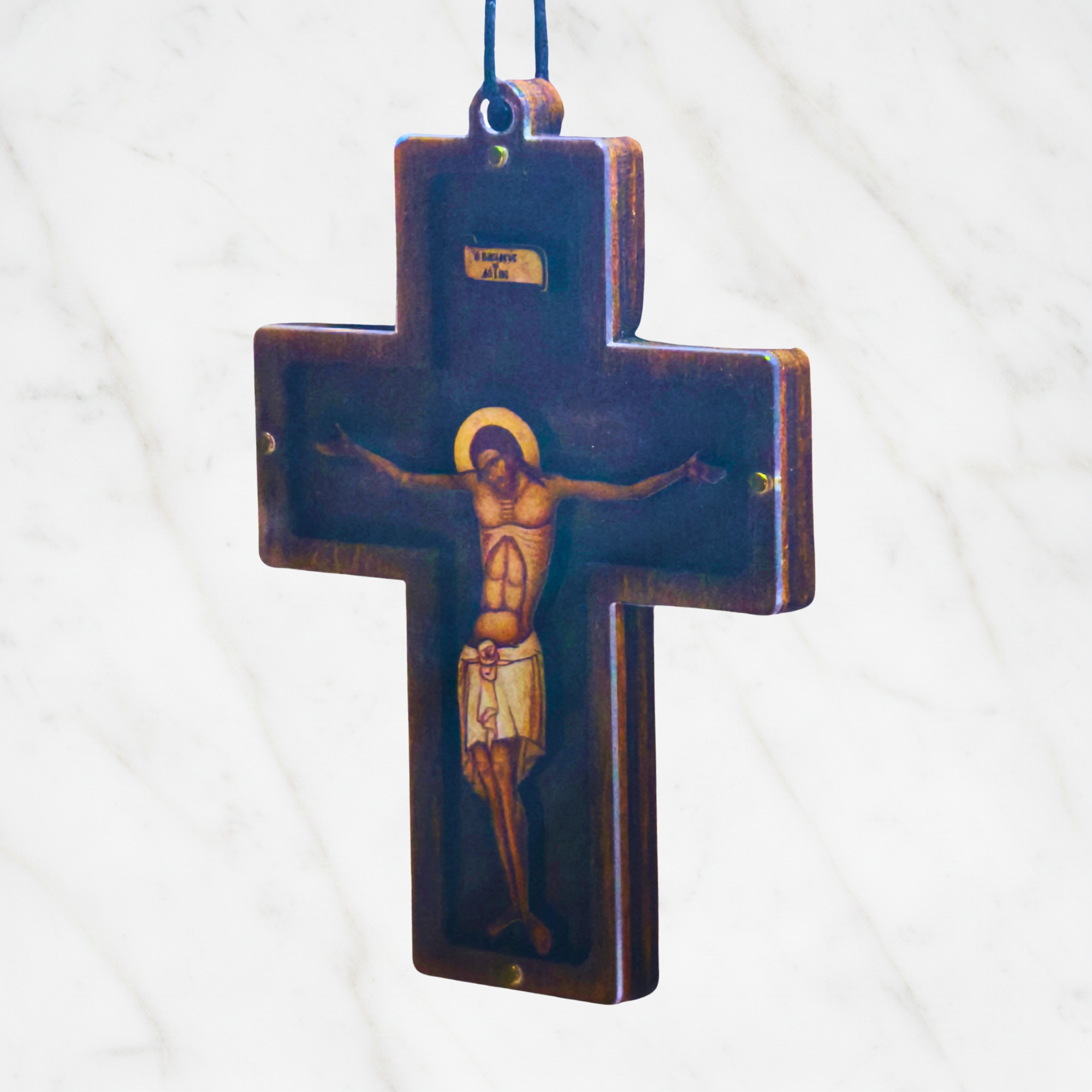 Orthodoxes Hängekreuz aus Walnussholz – Seitenansicht zeigt die Tiefe des Holzkörpers und die verschraubte Plexiglas-Front, Marmor-Hintergrund