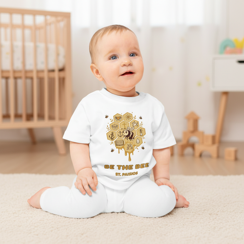 Weißes Bio-Baby-T-Shirt „Be the Bee“ als Lifestyle-Aufnahme mit Bienen- und Honigwabenmotiv