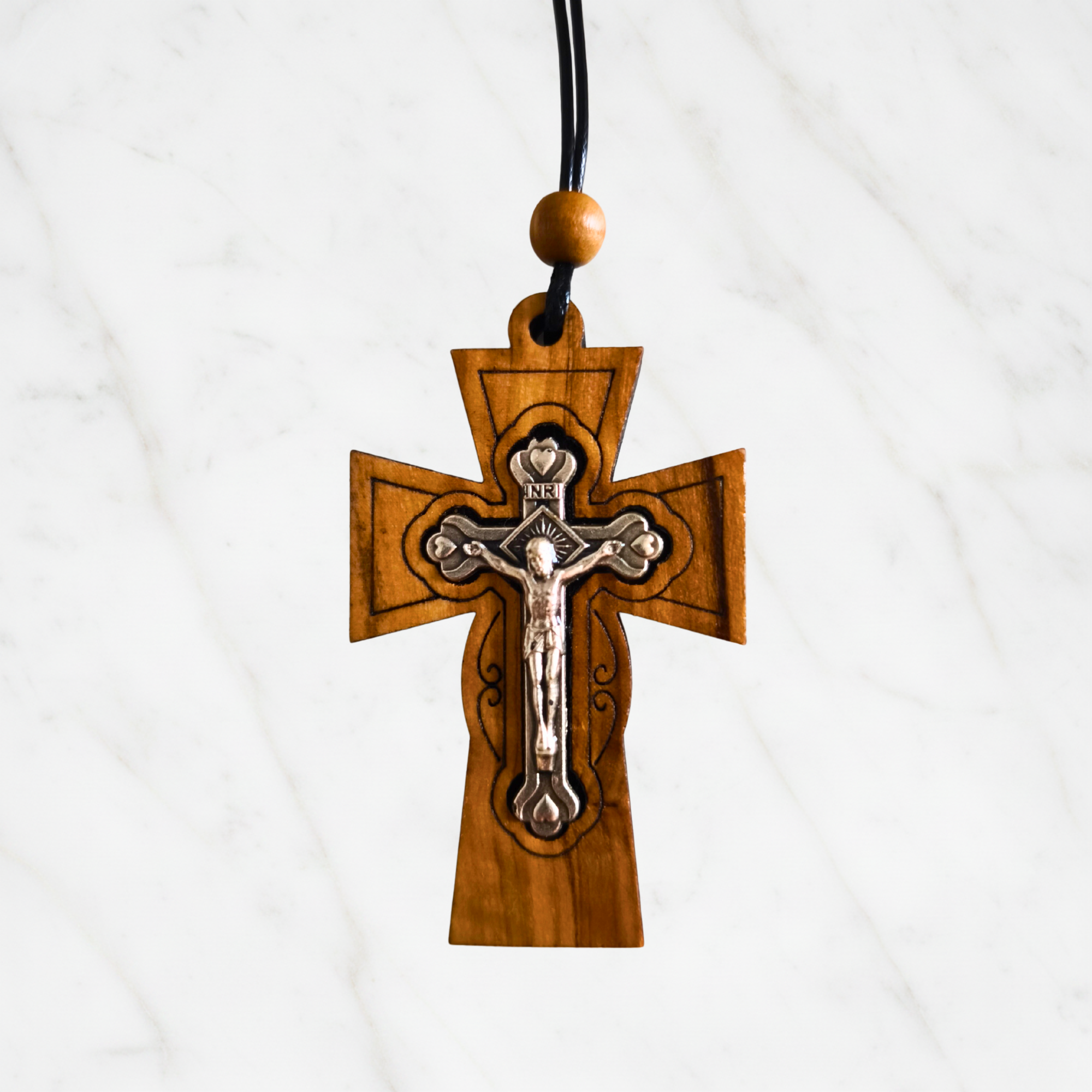 Kreuzanhänger aus Olivenholz – byzantinische Kreuzform mit silbernem Metallkorpus und INRI-Inschrift, handgefertigt in Bethlehem, 6 × 4 cm, Marmor-Hintergrund